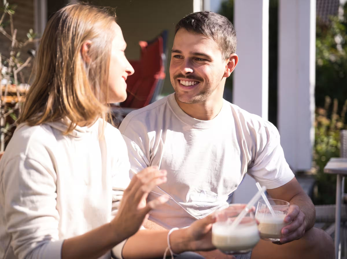 Pärchen zusammen auf der Terrasse trinkt einen Kwint Mykoprotein Shakes