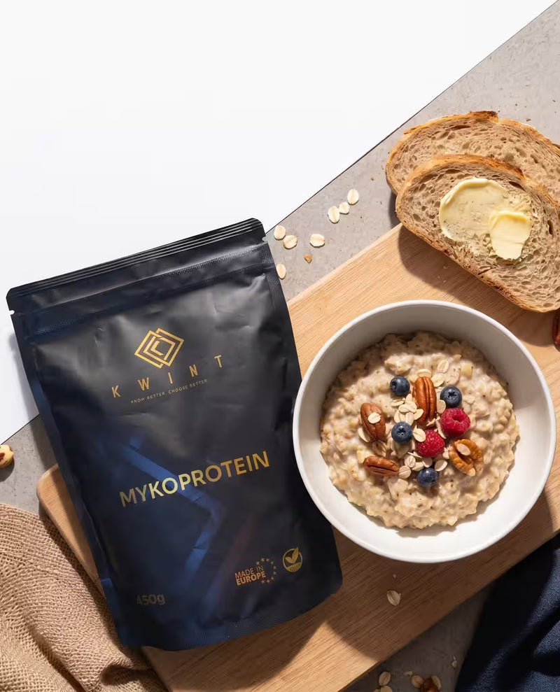 Frühstücksbrett mit Porridge und Brot, daneben liegt eine schwarze Packung Kwint Mykoprotein
