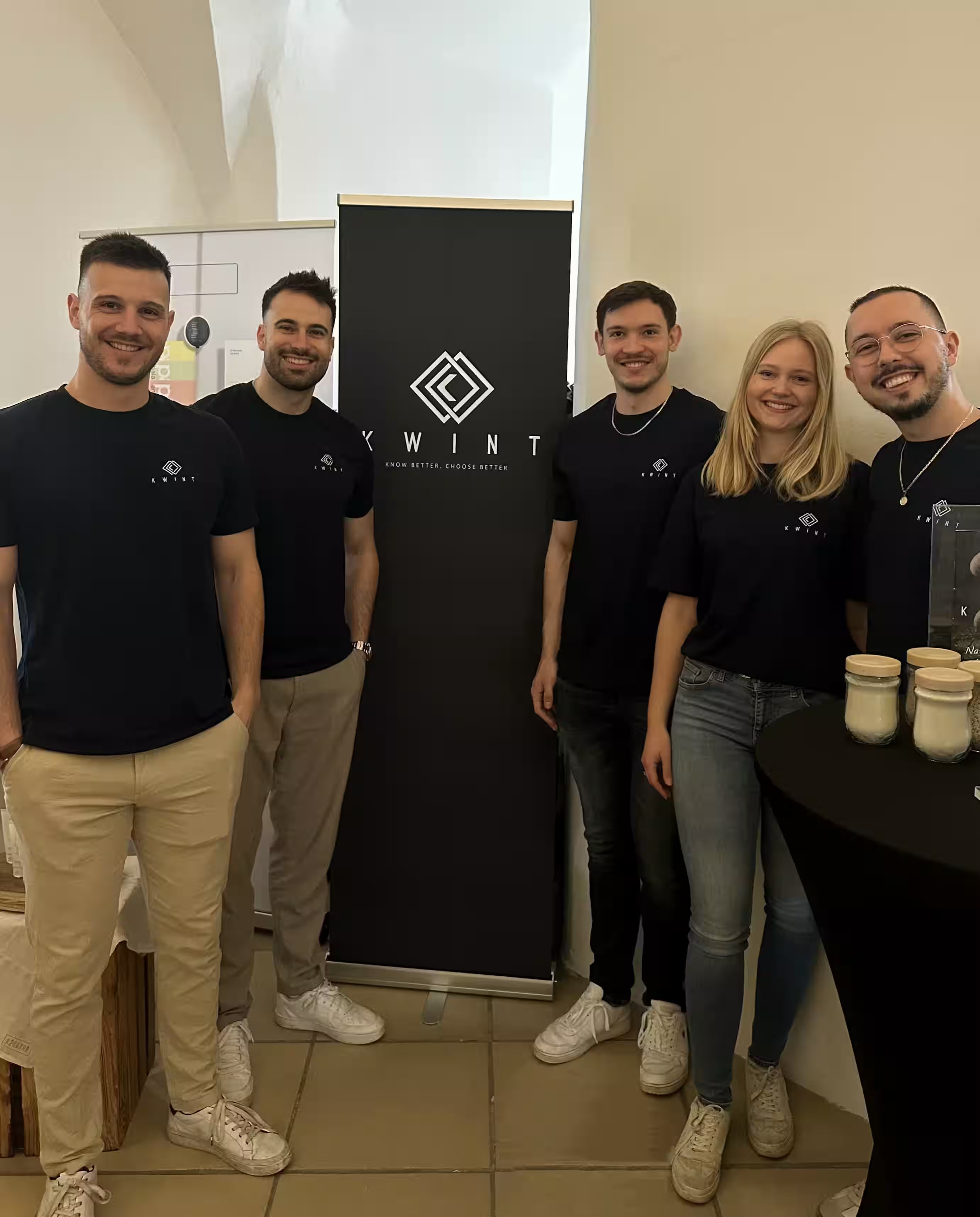 Das Team von Kwint auf einer Messe vor einem Roll-Up mit Kwint-Logo