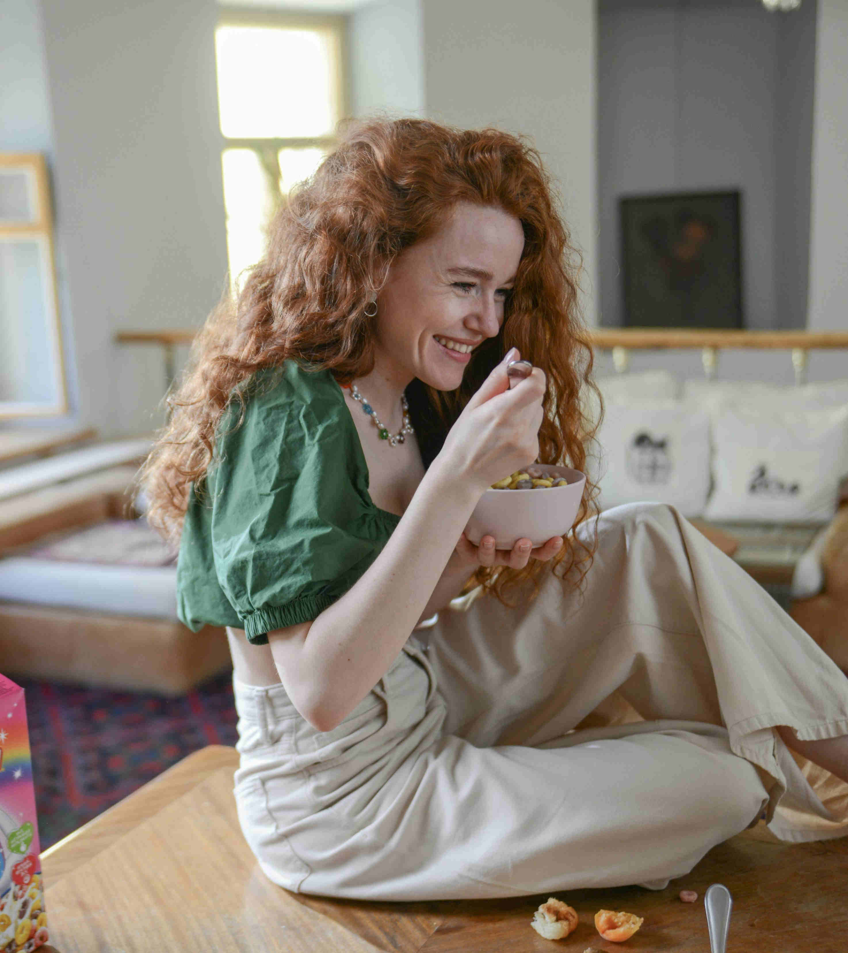 smiling girl eating cereal for breakfast