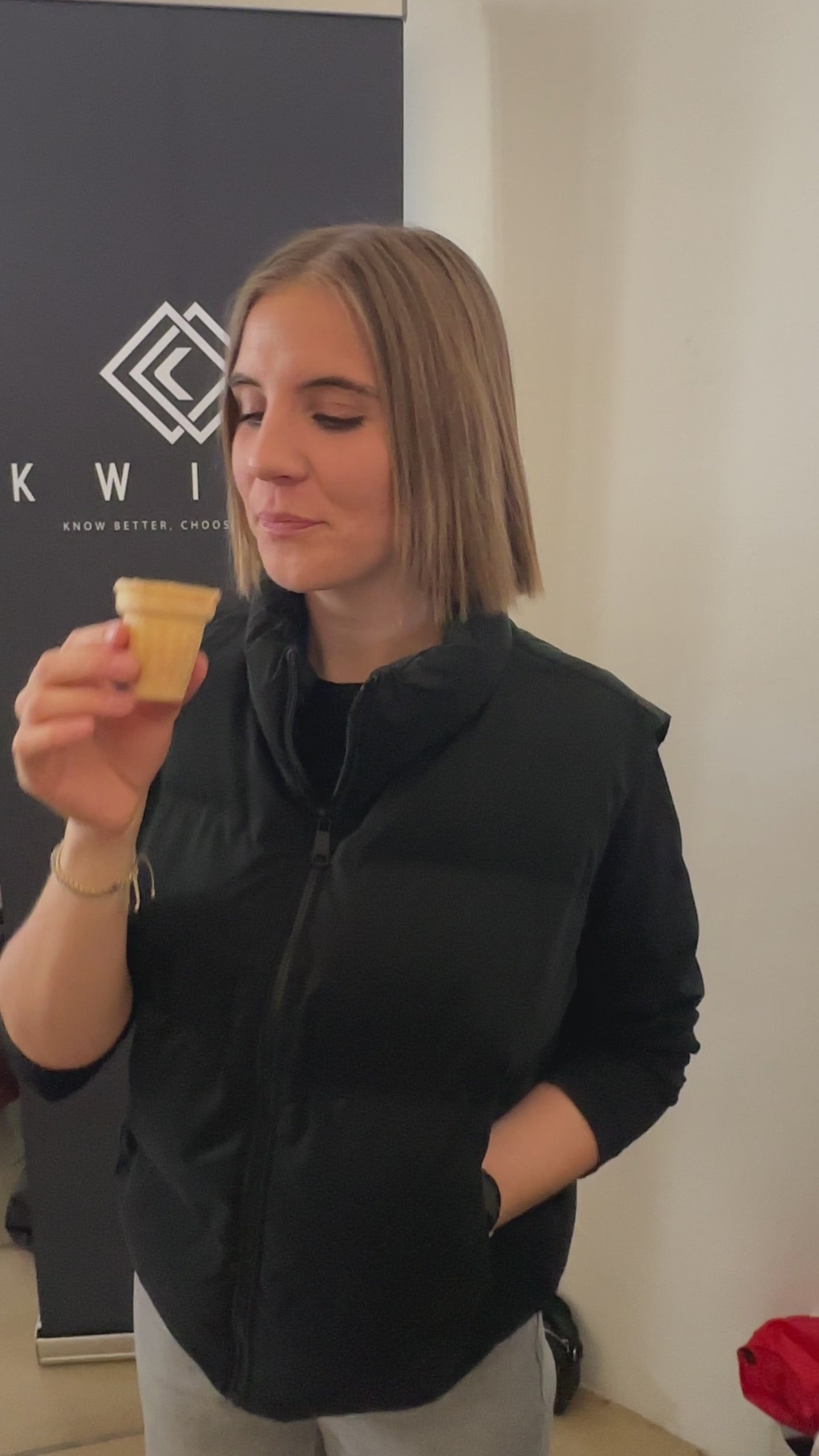 Junge Frau probiert einen Kwint Bananenshake und beantwortet die Frage des Interviewenden, dass es nicht nach Pilz schmeckt.